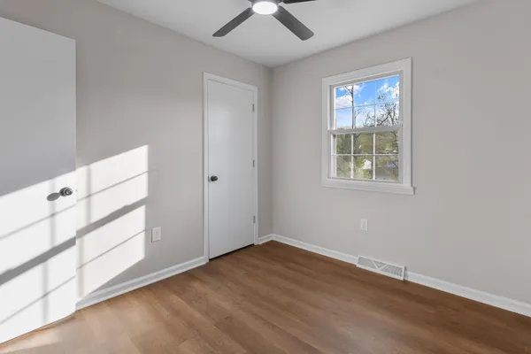 an empty room with a window and wooden floor
