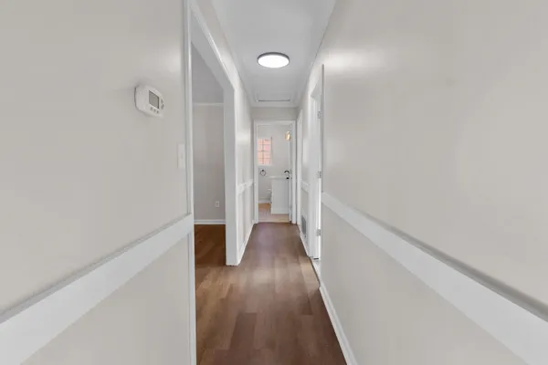 a view of a hallway with wooden floor