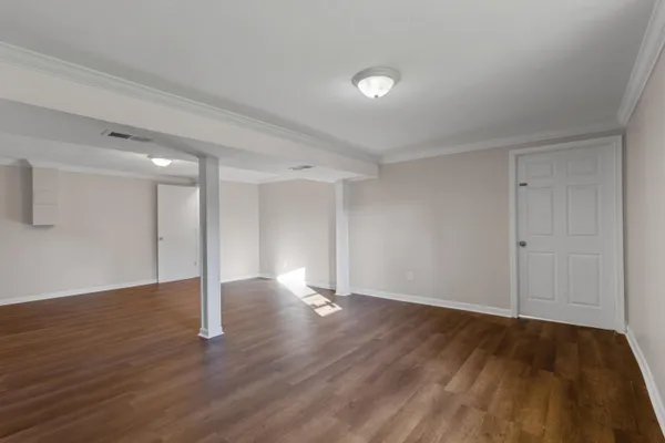 a view of an empty room with wooden floor