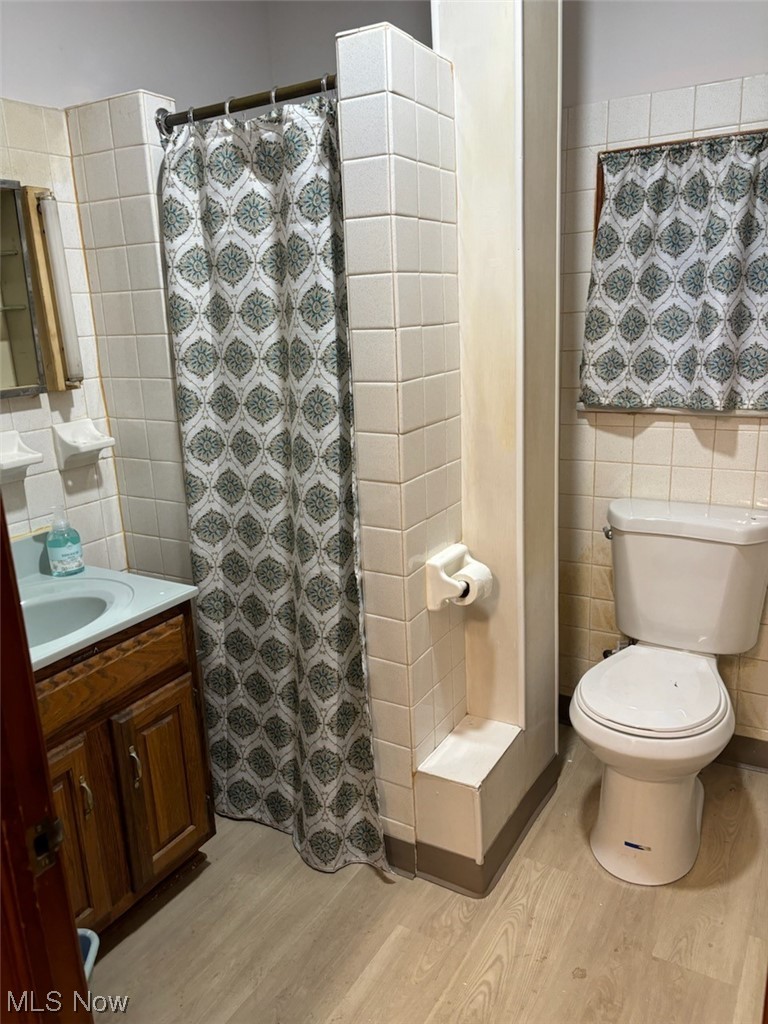 3700 Jaeger Road Lorain, OH 44053 - Photo 29 of 50 Bathroom with tile walls, vanity, toilet, and hardwood / wood-style floors
