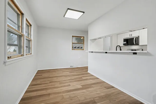 a view of a kitchen with wooden floor and a flat screen tv