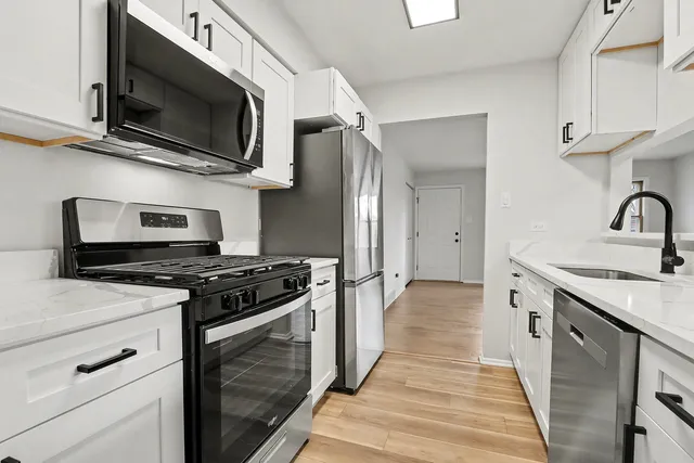 a kitchen with stainless steel appliances granite countertop a stove and a microwave