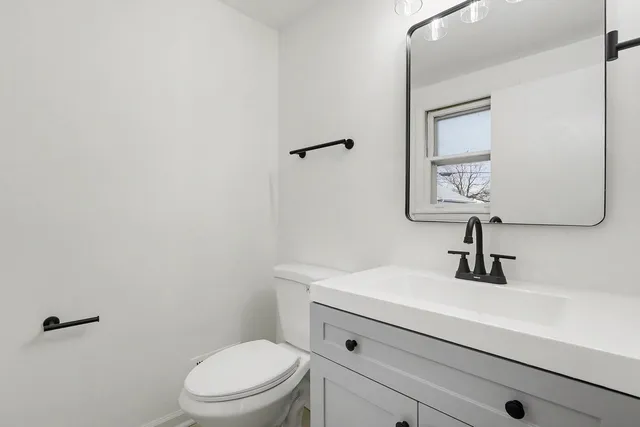 a bathroom with a sink a toilet and mirror
