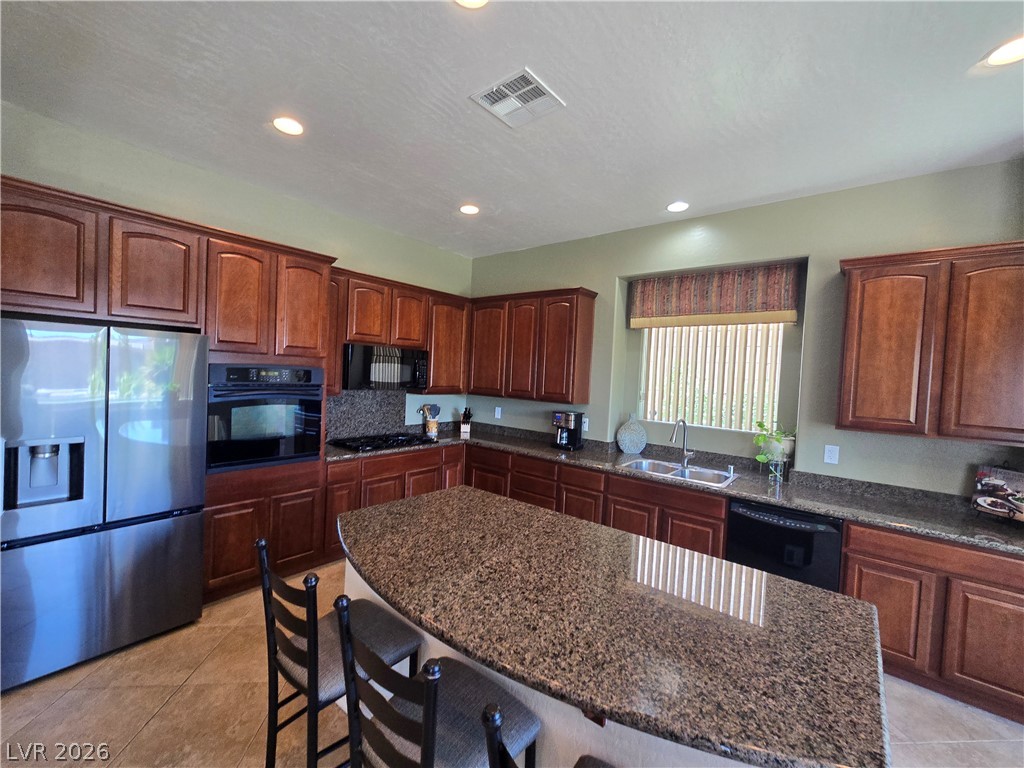 2567 Dirleton Place Henderson, NV 89044 - Photo 11 of 67 A chef's delight, this kitchen features rich wooden cabinetry and polished granite countertops.