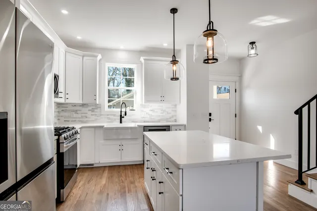 a kitchen with a sink a center island a stove and a refrigerator