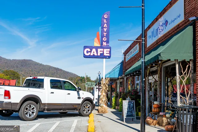 a view of the patio with dining table and chairs under an umbrella