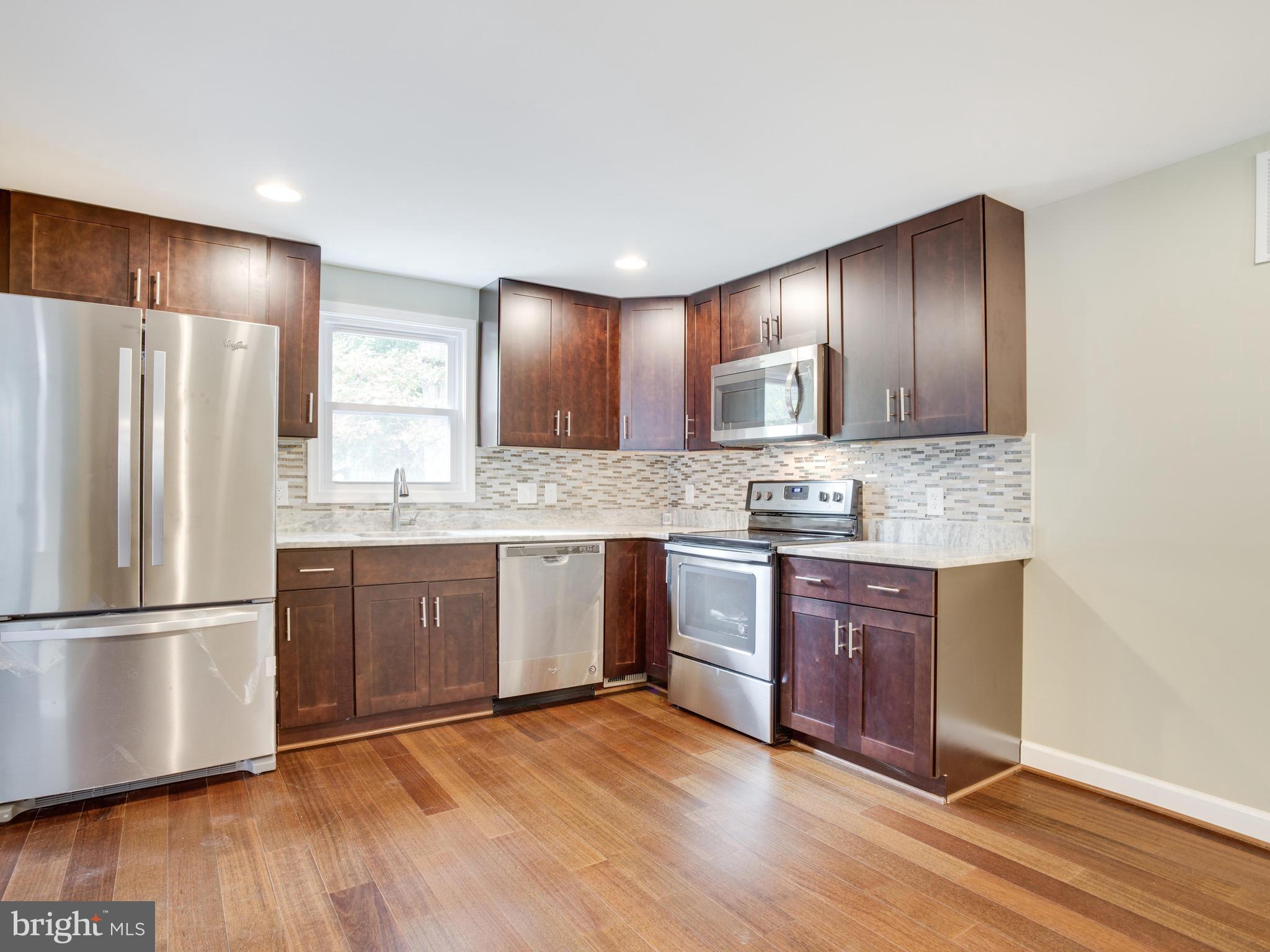3411 Oaklawn Road Fort Washington, MD 20744 - Photo 4 of 30 a kitchen with granite countertop wooden floors stainless steel appliances and cabinets