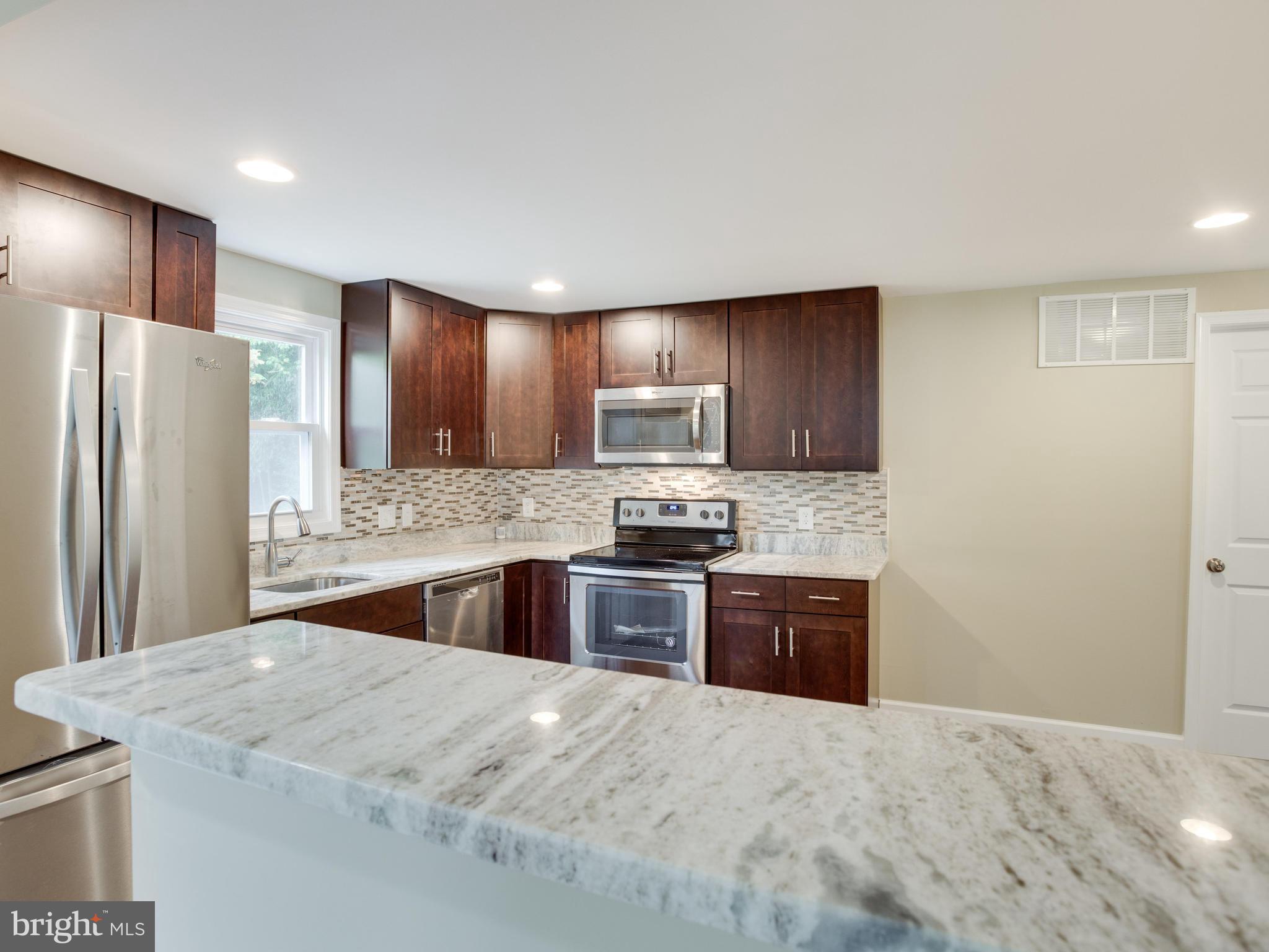 3411 Oaklawn Road Fort Washington, MD 20744 - Photo 5 of 30 a kitchen with granite countertop wooden cabinets a refrigerator and a sink