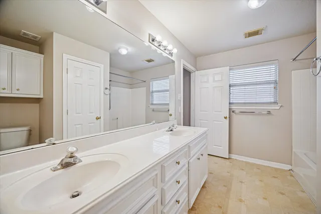 a spacious bathroom with a double vanity sink mirror and double