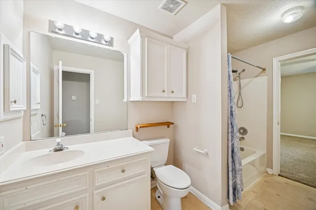 a bathroom with a granite countertop sink toilet a mirror a vanity and shower