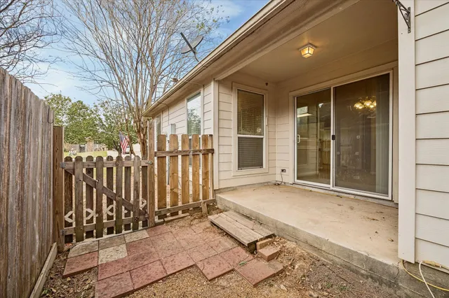 a view of backyard with wooden fence and large trees