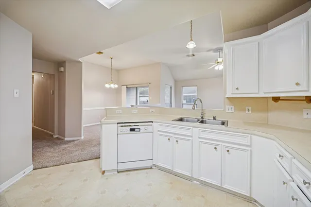 a kitchen with white cabinets and white appliances