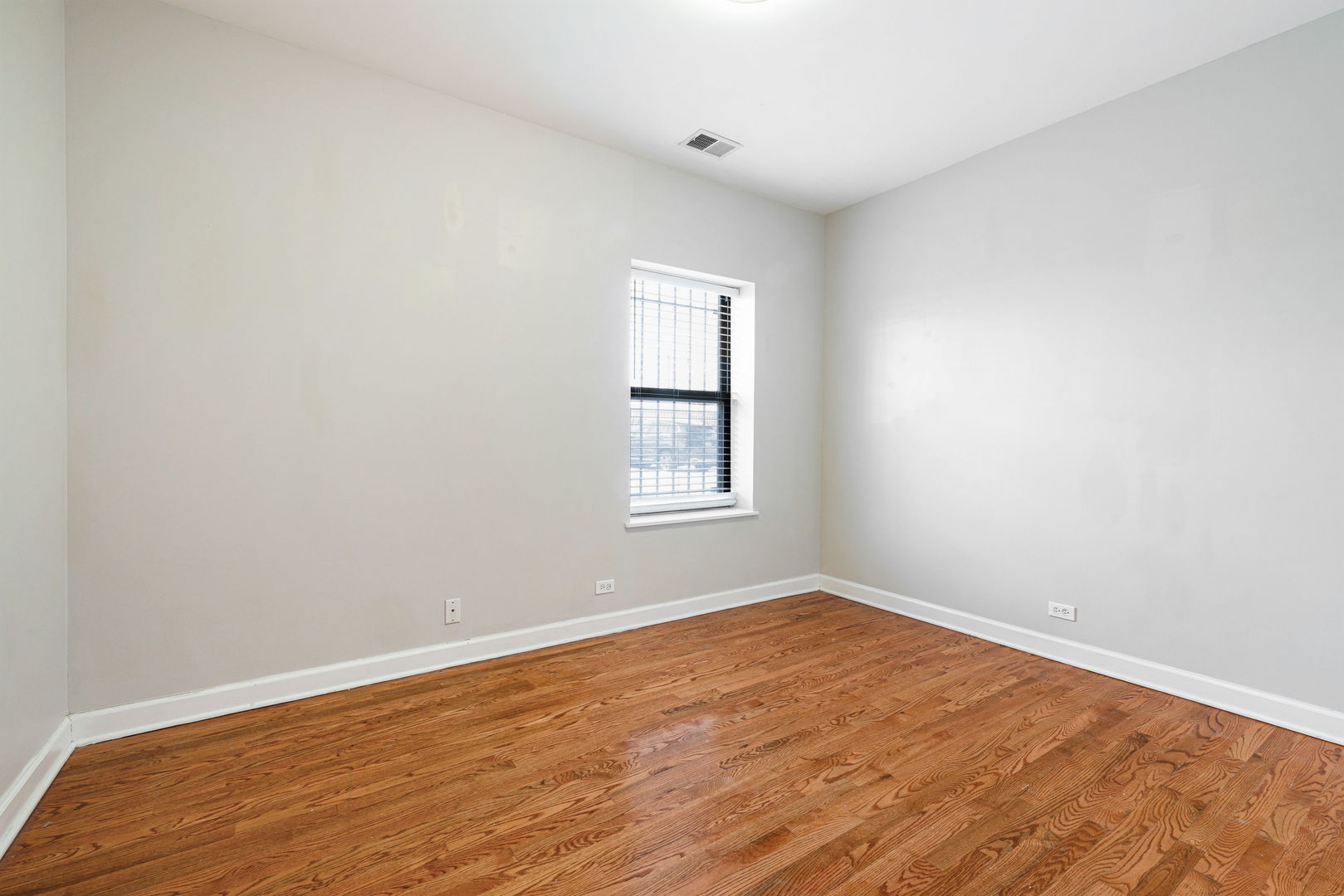 6324 South Kimbark Avenue, Unit 104 Chicago, IL 60637 - Photo 13 of 18 an empty room with wooden floor and windows