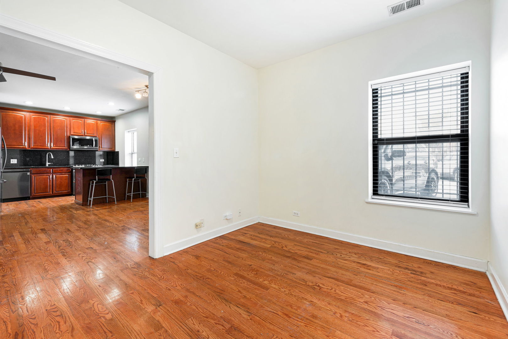 6324 South Kimbark Avenue, Unit 104 Chicago, IL 60637 - Photo 14 of 18 an empty room with wooden floor and windows