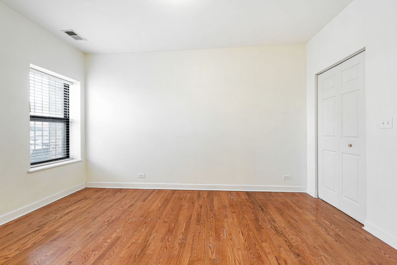 6324 South Kimbark Avenue, Unit 104 Chicago, IL 60637 - Photo 16 of 18 an empty room with wooden floor and windows