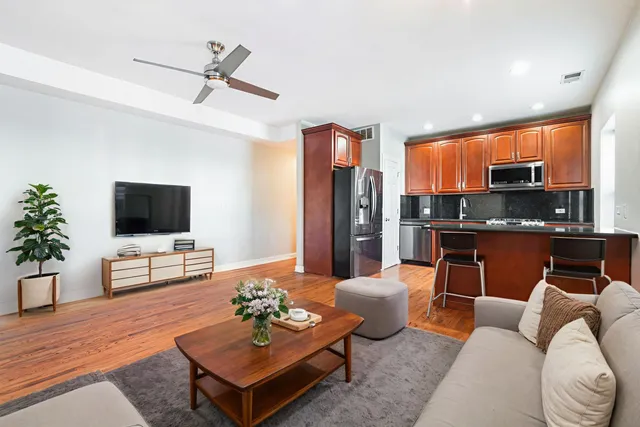 a living room with furniture kitchen view and a window