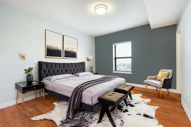 a bedroom with a bed and wooden floor
