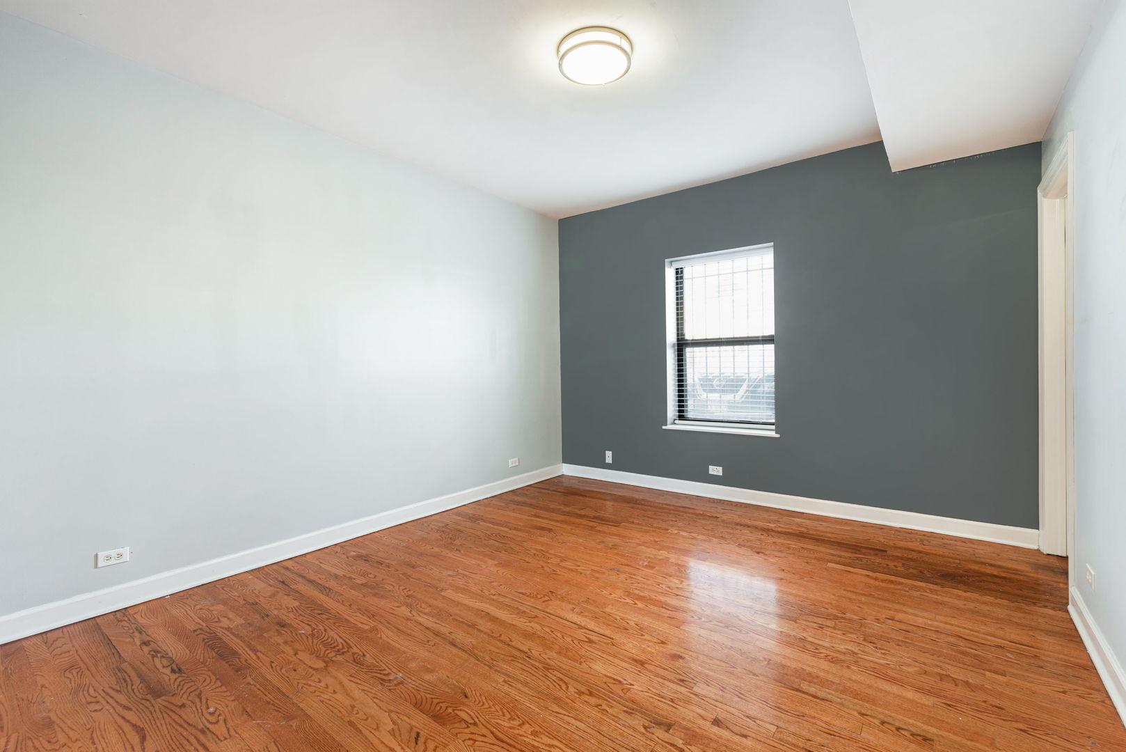 6324 South Kimbark Avenue, Unit 104 Chicago, IL 60637 - Photo 10 of 18 an empty room with wooden floor and windows
