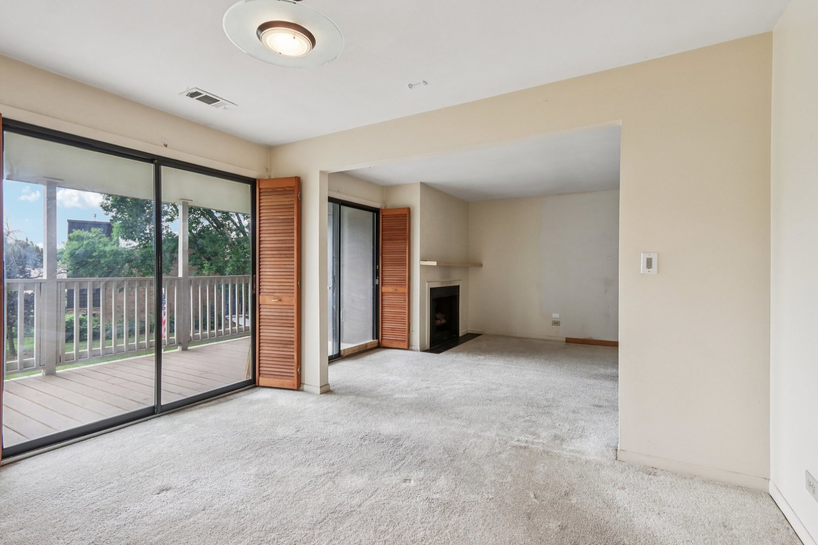 1495 South County Farm Road, Unit 24 Wheaton, IL 60189 - Photo 9 of 26 an empty room with sliding glass door and windows
