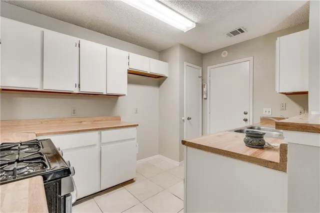 a kitchen with granite countertop a sink stove and cabinets