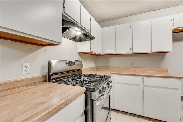 a kitchen with white cabinets and appliances