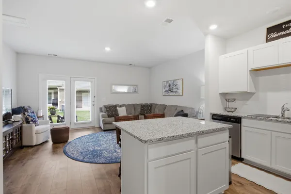 a kitchen with a stove a sink and dishwasher with white cabinets