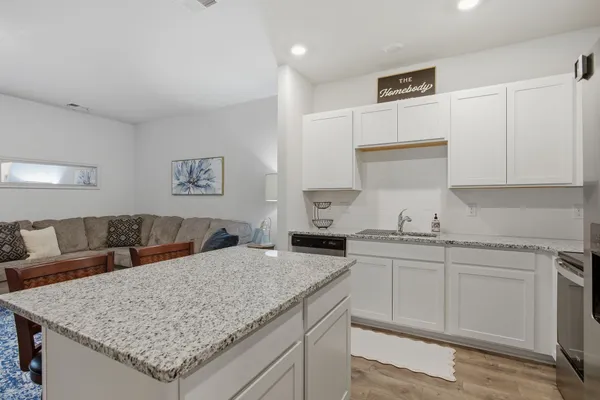 a kitchen with granite countertop a sink and stainless steel appliances