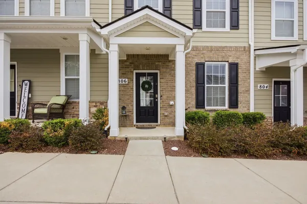 front view of a brick house with a small yard