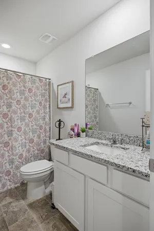 a bathroom with a toilet and a shower curtain