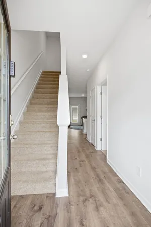 a view of a hallway with wooden floor and staircase