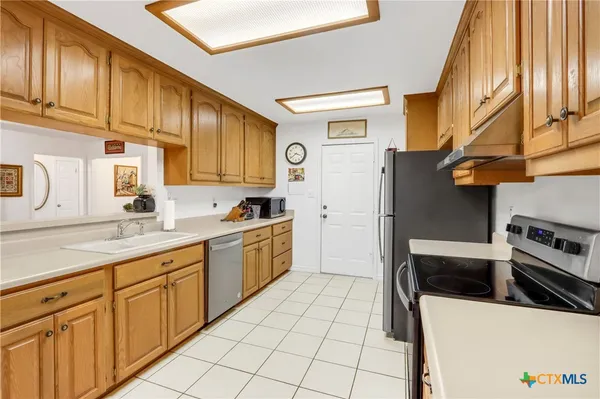 a kitchen with stainless steel appliances a refrigerator sink and cabinets