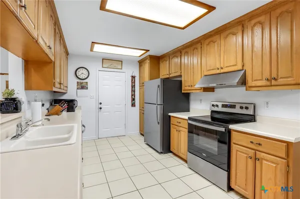 a kitchen with a refrigerator sink and cabinets