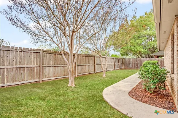 a view of a backyard with wooden fence