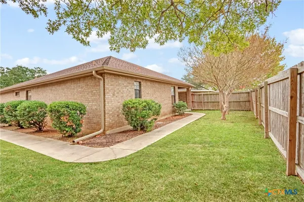 a view of a house with backyard and a tree