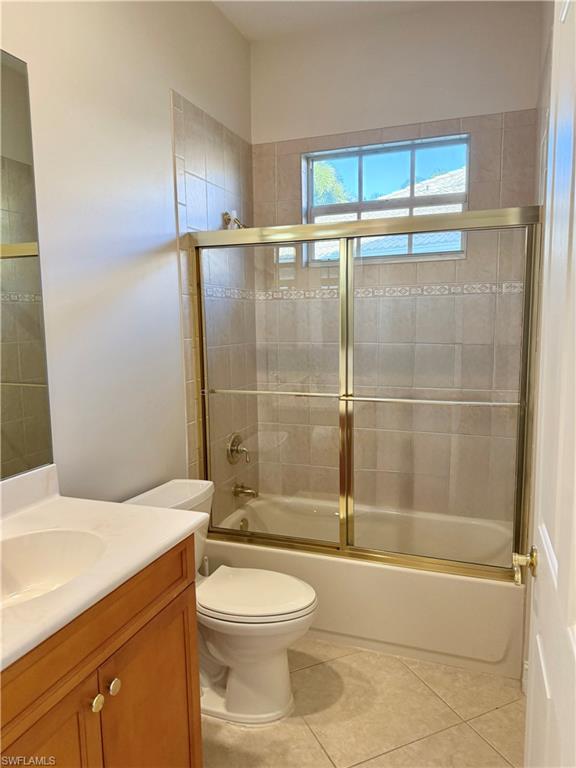 5031 Rustic Oaks Circle Naples, FL 34105 - Photo 11 of 15 Bathroom with bath / shower combo with glass door, vanity, and light tile patterned floors