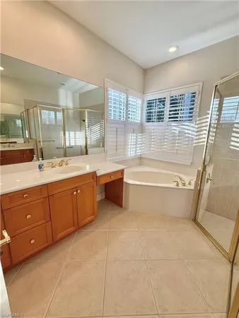 a spacious bathroom with a tub sink shower and mirror