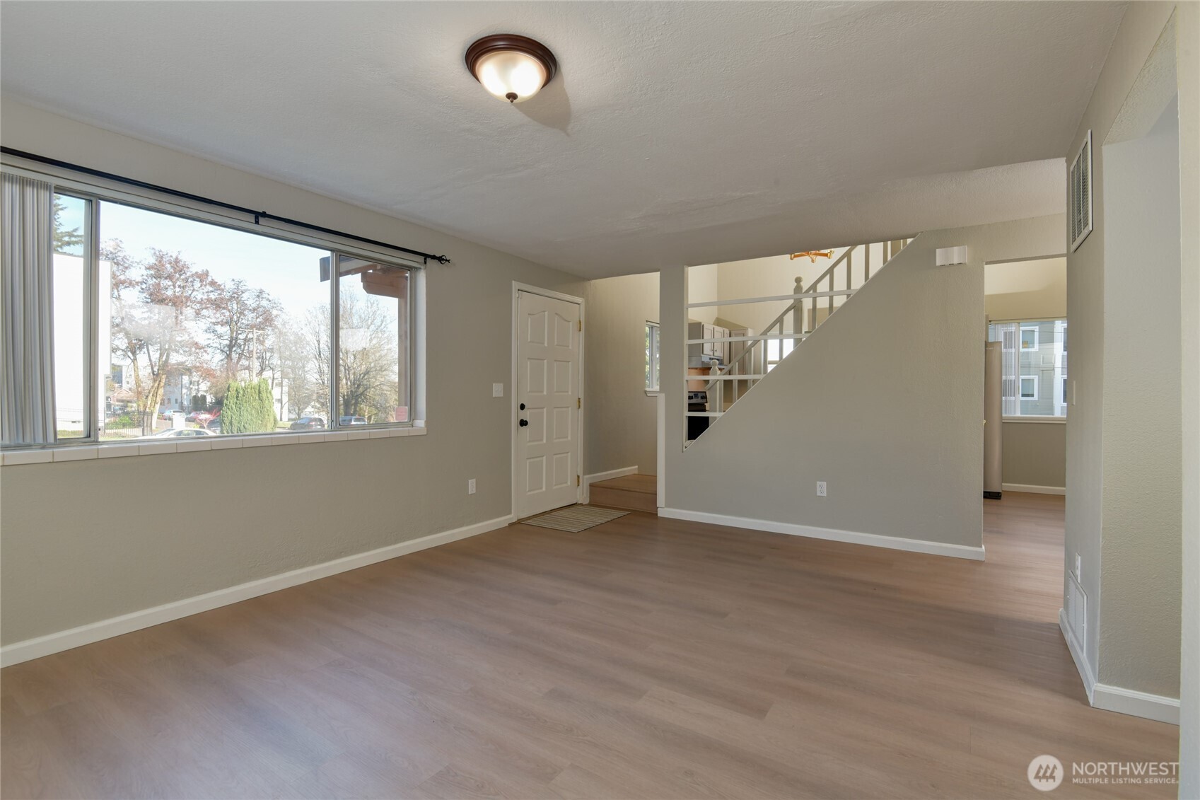1702 South G Street Tacoma, WA 98405 - Photo 3 of 25 an empty room with wooden floor and windows