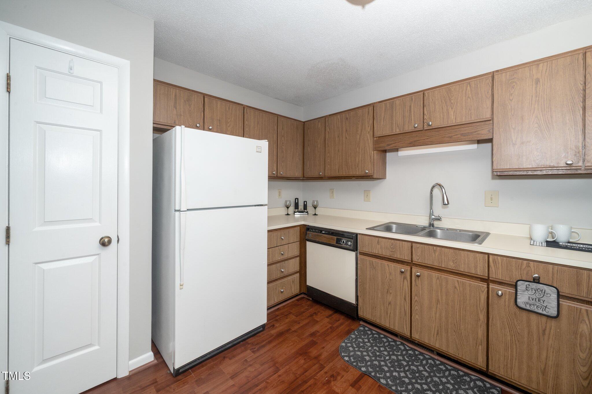 6016 Farm Gate Road Raleigh, NC 27606 - Photo 10 of 23 a kitchen with sink a refrigerator and cabinets