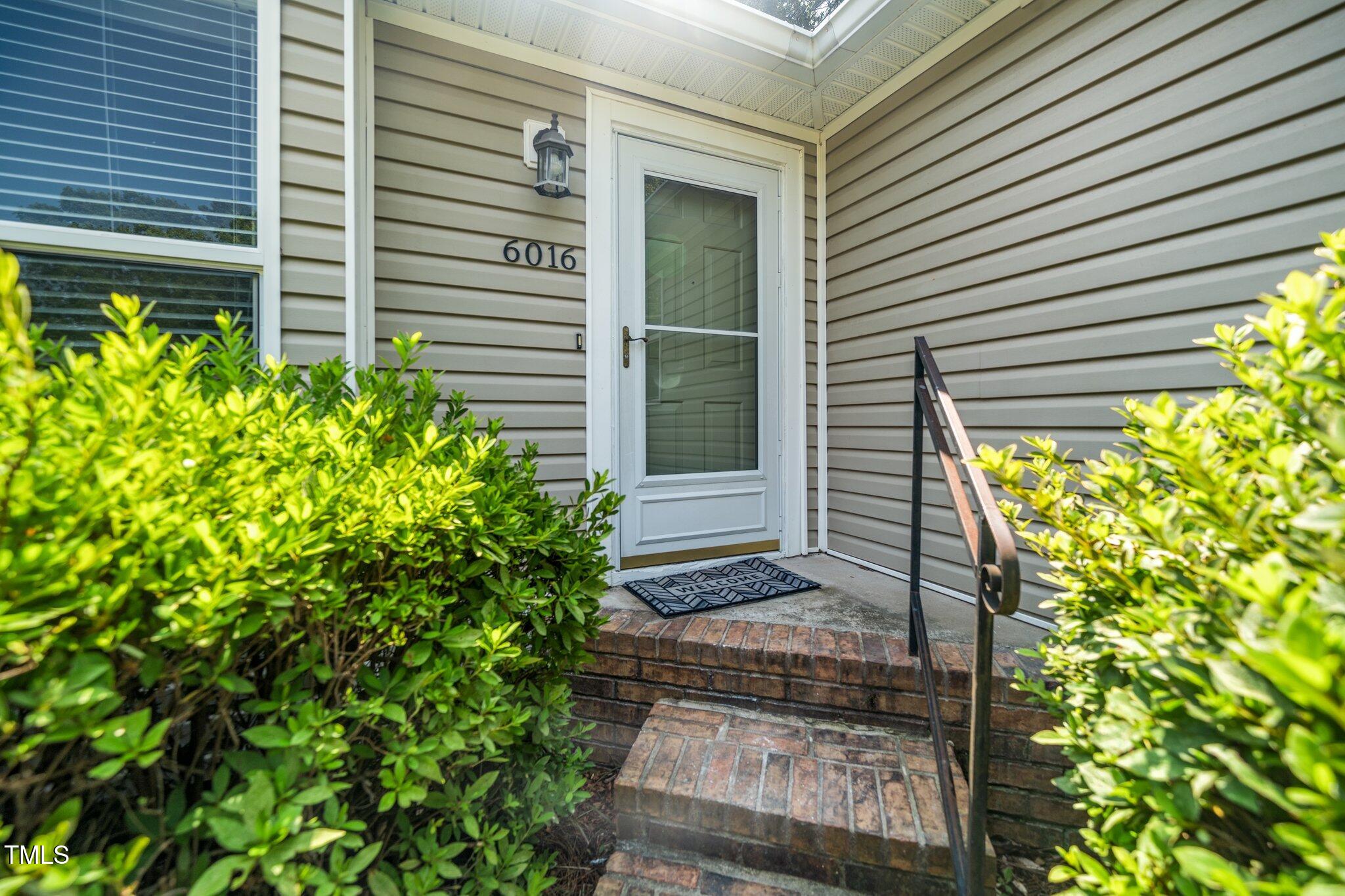 6016 Farm Gate Road Raleigh, NC 27606 - Photo 21 of 23 a house with a yard and potted plants