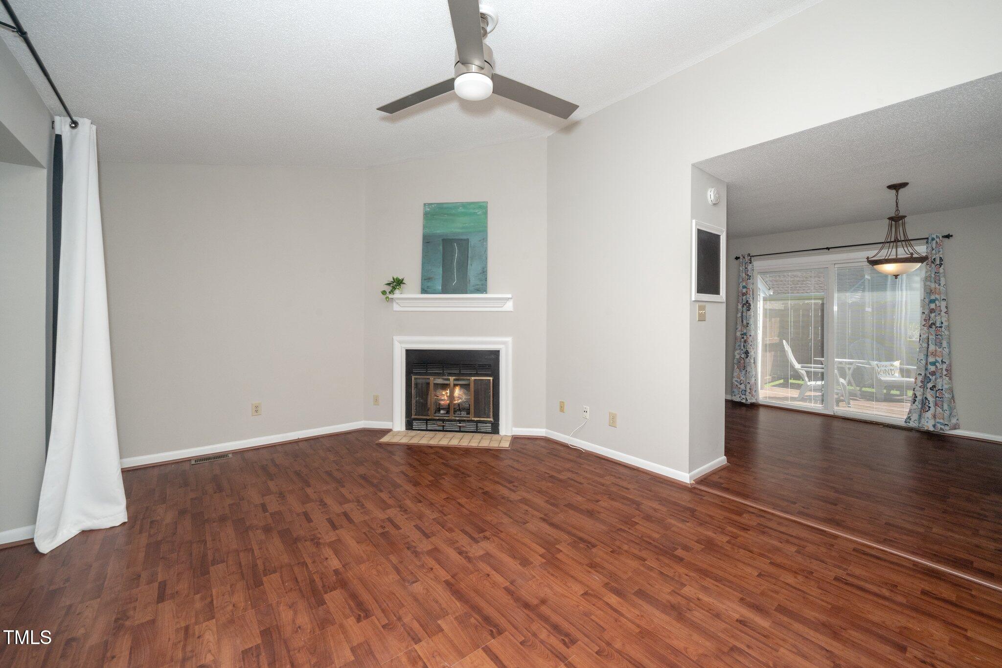 6016 Farm Gate Road Raleigh, NC 27606 - Photo 3 of 23 a view of an empty room with wooden floor fireplace and a window