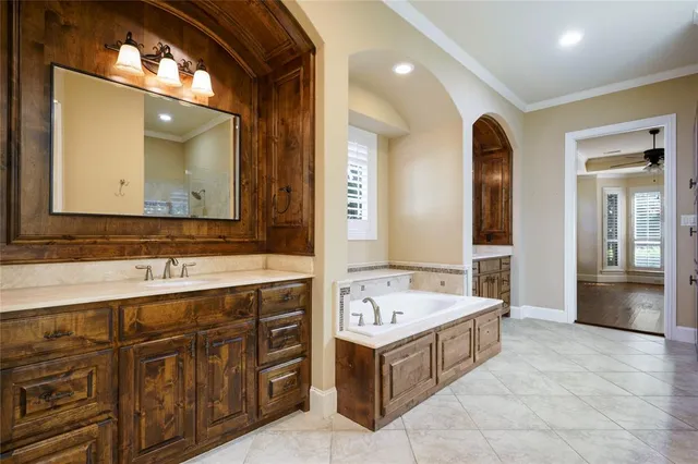 a spacious bathroom with a tub double sink and mirror