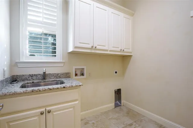 a bathroom with a granite countertop sink and a window