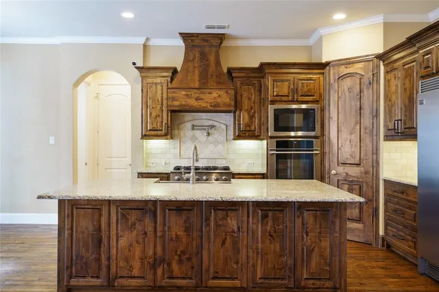 a kitchen with kitchen island granite countertop a refrigerator stove and oven