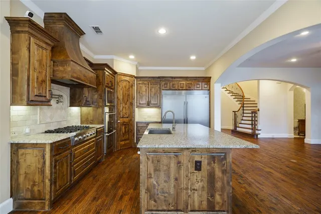 a kitchen with stainless steel appliances granite countertop a stove and a wooden floors