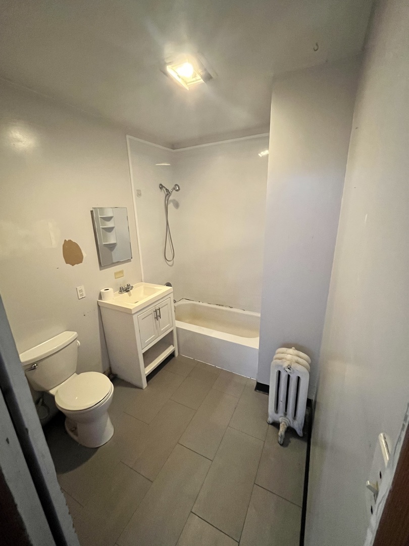 2913 East 97th Street Chicago, IL 60617 - Photo 9 of 16 a bathroom with a toilet sink and mirror