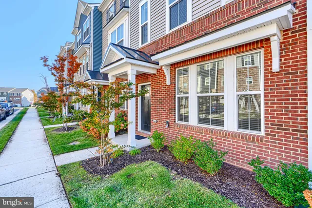 front view of a house with a yard and potted plants