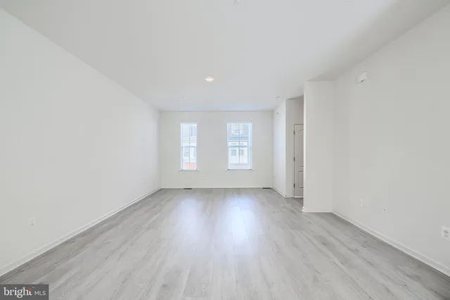 an empty room with wooden floor and window