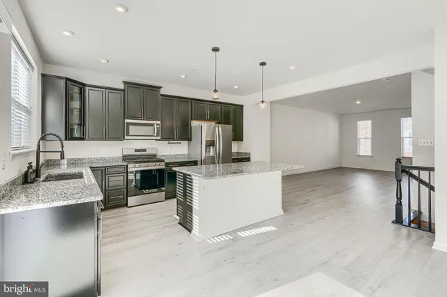 a large kitchen with kitchen island a sink stainless steel appliances and cabinets