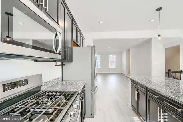 a kitchen with kitchen island granite countertop a stove and a sink