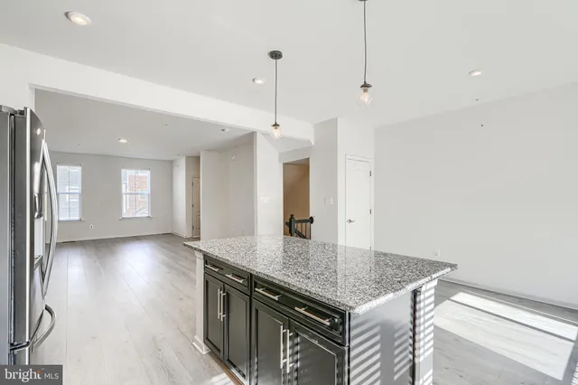 a kitchen with granite countertop kitchen island a sink appliances and a counter space